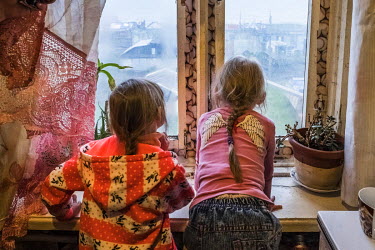 Nadia (four, right) and her sister Valentina (seven, left) looking out of a window in their godfather's apartment in the Oktyabrsky.