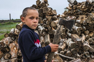 Nine-year-old Roman Revzin helping chop firewood in a fishing camp on the banks of the Bolshaya River.