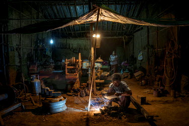 A man welds parts in a metal shop that repairs winches and generators used for oil extraction at Nga Naung Mone, Myanmar's largest unregulated oil field.