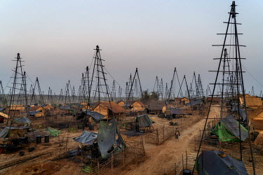 A person walks past the makeshift derricks at Nga Naung Mone, Myanmar's largest unregulated oil field.