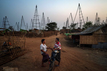 Two men chat at dusk at Nga Naung Mone, Myanmar's largest unregulated oil field.