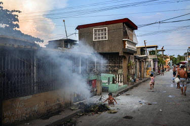 A child pokes at a pile of smouldering rubbbish in Manila North Cemetery. Manila North Cemetery is home to thousands of 'informal settlers' who have built shacks using in and around the mausoleums, cr...
