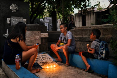 Visitors pay their respects and pray at a family tomb at Manila North Cemetery.  Manila North Cemetery is home to thousands of 'informal settlers' who have built shacks using in and around the mausole...