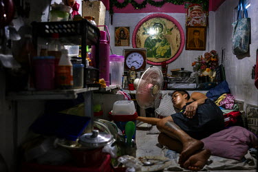 A man sleeps on the tomb a shack has been built over in Manila North Cemetery. Manila North Cemetery is home to thousands of 'informal settlers' who have built shacks using in and around the mausoleum...