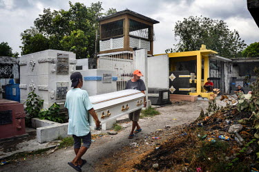 Funeral workers carry the coffin of Glen Balena, 26, during his funeral at Manila North Cemetery. Manila North Cemetery is home to thousands of 'informal settlers' who have built shacks using in and a...