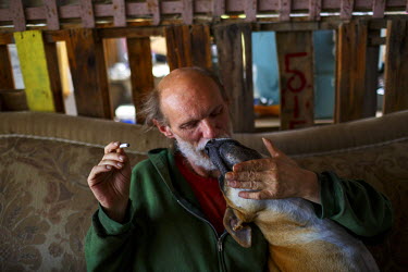 Kent, 52, playing with his dog. He is from Washington State and has Parkinson's disease. About four years ago, he came for a short visit to see his best friend in Slab City, a squatters' camp about 19...