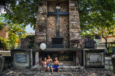Children play amongst tombs in Manila North Cemetery.  Manila North Cemetery is home to thousands of 'informal settlers' who have built shacks using in and around the mausoleums, crypts and tombs. In...