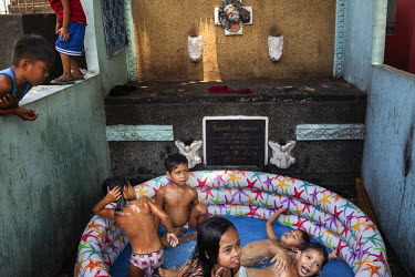 Children play in a paddling pool set up among the tombs in Manila North Cemetery.  Manila North Cemetery is home to thousands of 'informal settlers' who have built shacks using in and around the mauso...