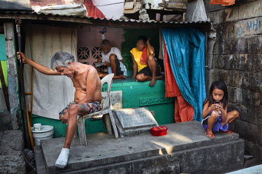Residents socialise on tombs in Manila North Cemetery.  Manila North Cemetery is home to thousands of 'informal settlers' who have built shacks using in and around the mausoleums, crypts and tombs. In...