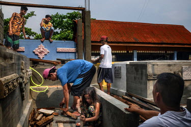 Workers build an extension on top of other tombs in Manila North Cemetery.  Manila North Cemetery is home to thousands of 'informal settlers' who have built shacks using in and around the mausoleums,...