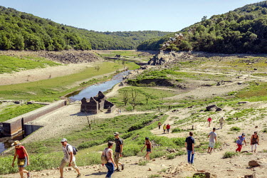 People explore the dried bed of Lac de Guerledan, drained in 2015 to enable maintenance. The artificial lake was excavated to create a reservoir to supply a hydro-electric station and has been emptied...
