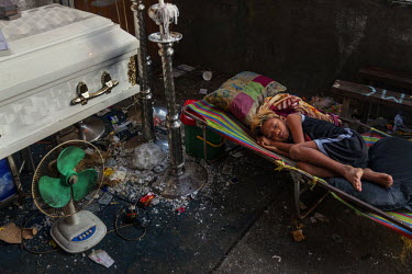 Jhon Ryan, 11, lies beside the coffin of his father Joaquin Garbo, 36, at his wake a few hours before his funeral, at Navotas Fishing Port. Joaquin was abducted and executed in what appears to be a dr...