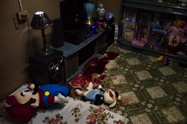 Children's toys, covered in blood, lie on the floor in the bedroom of Danilo Bolante, a drug user who had previously surrendered to police in an amnesty, only to be killed in what appears to be a drug...