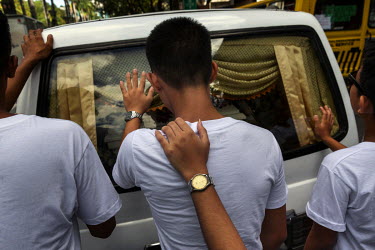 Children walk behind the hearse carrying the body of Christian Camungol, 35, who was killed on 25 November 2016 along with five others in what appeared to be drug-related executions, weeps over his co...