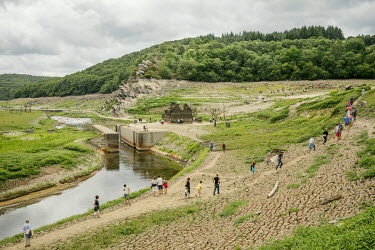People explore the dried bed of Lac de Guerledan, drained in 2015 to enable maintenance. The artificial lake was excavated to create a reservoir to supply a hydro-electric station and has been emptied...
