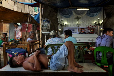 Pacito Manas, sleeps at the wake of Christian Mufable, 34, his nephew, who was killed on 21 November during a police anti-drugs operation. It is customary that the body is not left unattended during t...