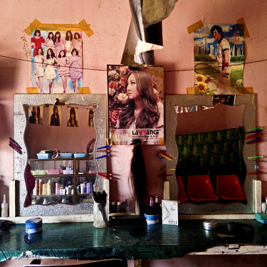 Posters and photographs decorate the wall of a hair dressing salon.