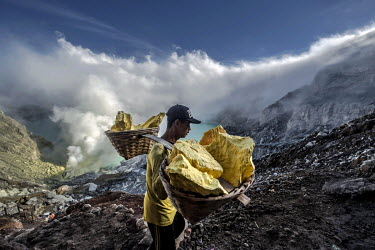 Nurdin, a young miner, climbs the slope of the Ijen volvano crater carrying a load of sulphur. More than 200 people come here daily to collect sulphur, which occurs naturally in volcanic emissions. Af...