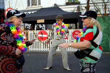 Three elderly people dancing to a sound system at the Notting Hill Carnival.