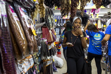 Customers shop for hair extensions and supplies at a busy shop called Feirao dos Doces e Brinquedos, or the Big Fair of Sweets and Toys, in Rio's north side neighborhood of Madureira.