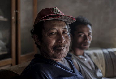 Wahyudi, 24, sits with his father, Ambriono, who spent decades mining sulphur at the Kawah Ijen crater. With Ambriono now too old to continue working, Wahyudi is single-handedly supporting his whole f...