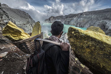 Miskadi, a 36 year old miner, takes a break as he hauls a load of sulphur up to rim of the Ijen volcano. More than 200 miners come daily to collect the sulphur which occurs naturally in volcanic emiss...
