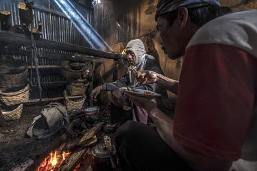 Sulphur miners share a meal and warm themselves by a fire in a hut on the slopes of the Ijen volcano. More than 200 miners come daily to collect the sulphur which occurs naturally in volcanic emission...