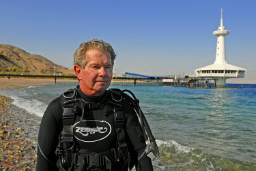 Benjamin Kahn sits on the shore of the Red Sea, moments after returning from a dive near his Coral World Underwater Observatory Marine Park.