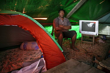 Avapura Joe Moses (46), the head of the Paga Hill community, sits in his tent, which was errected on the site of his demolished house. Moses and other elders pressed the charges in the court against t...