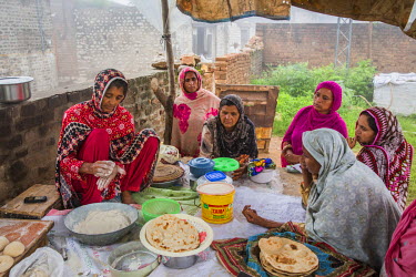 Kausar Shaheen bakes chapatis at her family bakery in Manhiala, Chakwal District. Kausar suffers from cataracts in both eyes that severely restrict her vision.