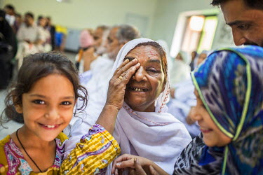 Zamurrad Bibi smiles in the company of her family after having her bandage removed a day after her cataract operation at the LRBT Eye Hospital in Mandra.