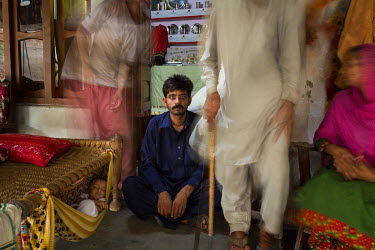 Murtaza Ghulum (30) is surrounded by members of his family at their shared home in Dhadda Kharu, near Pindi Bhaddian. Ghulum suffers from bilateral cataracts and was forced to leave his job in Saudi A...