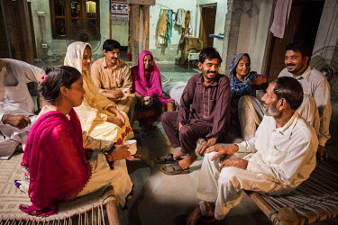 Murtaza Ghulum (30, in brown) sits with his family at their shared home in Dhadda Kharu, near Pindi Bhaddian. Murtaza suffered from bilateral cataracts and was forced to leave his job in Saudi Arabia...