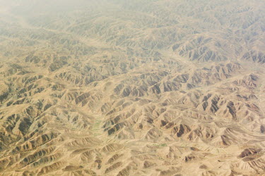 An aerial view of the Kubuqi desert, with small patches of farmed or planted ground in some of the valleys. The Kubuqi Desert is the seventh largest desert in China and lies to the north of Ordos Plat...