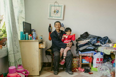 Wang Yue (65) with his grand daugther at home. Wang Yue is one of thousands of farmers who have been forced off their land to make way for the Chinese government's so-called 'Green Great Wall' project...