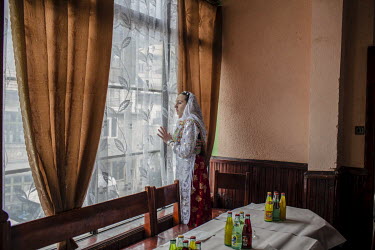 A Pomak (muslim) woman looks out for the arrival of the guests for a wedding meal.