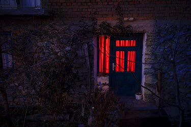 A doorway and window is illuminated in the early evening.