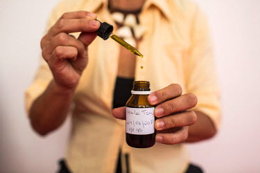 Margarete Santos de Brito with the cannabis oil they treat their daughter with. The oil does not contain THC, the he principal psychoactive constituent of cannabis. Margarete and her husband, Marcos L...