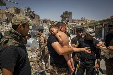 An unidentified young boy, who was carried out of the last area of ISIS control in the Old City by a man suspected of being a militant, is cared for special forces soldiers.