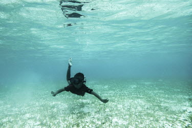 A Bajau child swims through a field of seagrass near his village of Pulo Papan in Sulawesi, Indonesia.