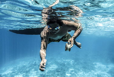 Marjono Lessing (35) dangles an octopus lure Kabalutan in Indonesia's Togean islands. Octopus is one of the main sources of income for the Bajau.