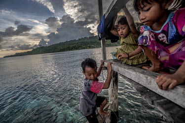 Bajau children play on the porch of their home in the stilt village of Pulo Papan.