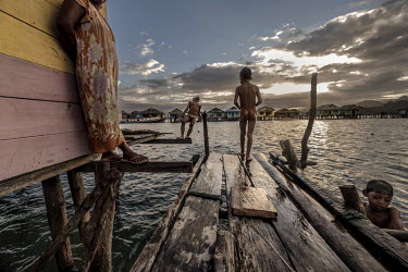 Bajau children play and swim in the stilt village of Kabalutan. In recent decades almost all Bajau have left their nomadic lifestyle in favour of the settled life in stilt villages throughout the 'Cor...