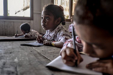 Bajau children takes notes in class in the stilt village of Kabalutan. Since giving up the nomdic life to settle in villages, the Bajau have been exposed to formal education for the first time.