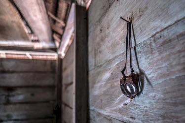 A pair of homemade Bajau diving goggles hangs on the wall of a Bajau fisherman's home in the stilt village of Kabalutan.