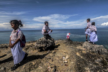 Bajau schoolchildren look out to sea during a break from class in the village of Kabalutan in the Togean Islands.