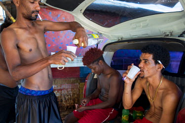 Young men drinking rum and smoking ganja after a swim in Salt River, a hot salt water spring in southern Jamaica.