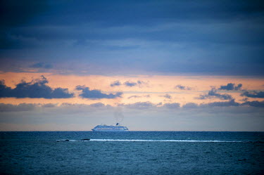A cruise ship off Discovery Bay makes its way along the northern coast of Jamaica at sunset.