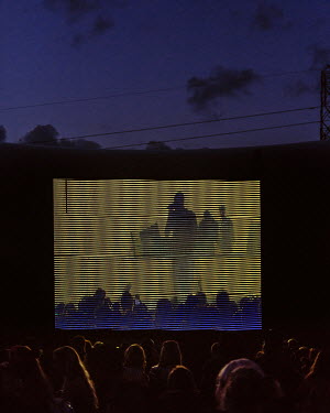 Revellers watch a performance on the big screen by UK Grime artist Skepta at the 2016 Glastonbury Festival.