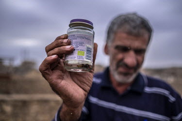 Qais Abdullah (55), who has been investigating crime scenes for the past 25 years, holds up a baby food jar in which he has stored samples containing DNA taken from the body of a person killed during...